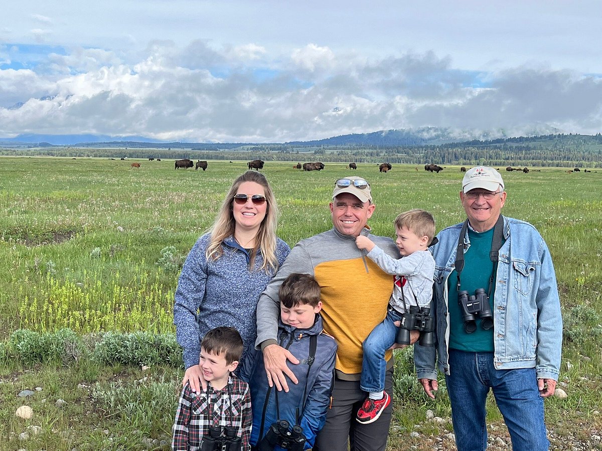 Family posing in front of vast Grand Teton valley