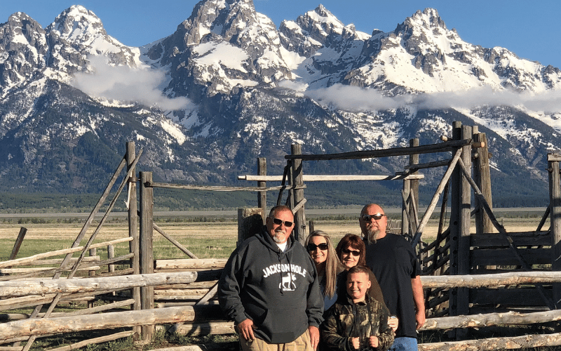 Tour group posing with panoramic backdrop of snow covered Tetons
